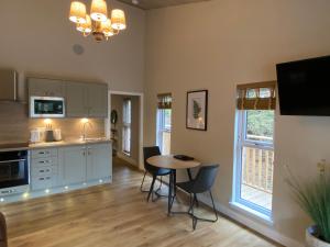 a kitchen with a table and chairs in a room at Holly Berry Lodge with Hot Tub in Cupar