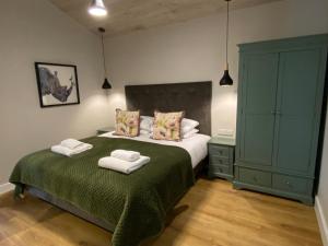 a bedroom with a bed with two towels on it at Holly Berry Lodge with Hot Tub in Cupar
