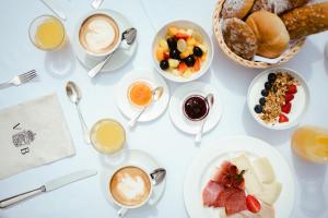 una mesa con tazas de café y platos de comida en Villa Bavaria en Merano
