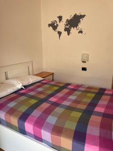 a bedroom with a bed with a multicolored blanket at Hotel Culmine in Ardenno