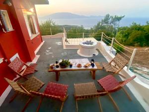 une terrasse avec des chaises et une table sur une maison dans l'établissement Coralina Cottage, à Koríthion