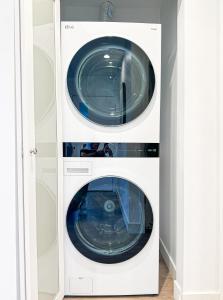 a washer and dryer in a white cabinet at Modern 2BR Oasis - Cal-Cal in Calabasas