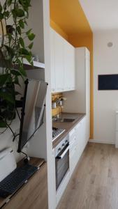 a kitchen with white cabinets and a laptop on a desk at La casetta di Cecilia in Trani