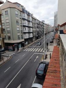 uma rua vazia com carros estacionados ao lado de um edifício em Sonetos - Guest House no Porto