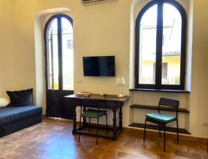 ein Wohnzimmer mit einem Schreibtisch und 2 Fenstern in der Unterkunft Terraces under the Moon in Rom