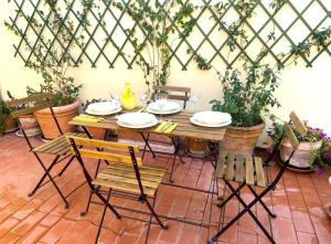 einen Tisch und Stühle auf einer Terrasse mit Pflanzen in der Unterkunft Terraces under the Moon in Rom