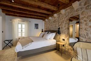 um quarto com uma cama grande e uma parede de pedra em Modern Stone House, luxury suites in Dubrovnik Old Town em Dubrovnik