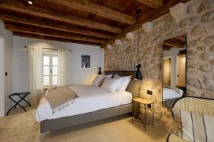 ein Schlafzimmer mit einem großen Bett und einer Steinwand in der Unterkunft Modern Stone House, luxury suites in Dubrovnik Old Town in Dubrovnik