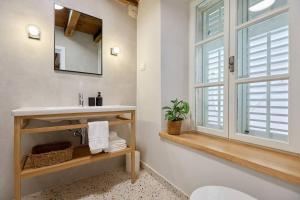 uma casa de banho com um lavatório, um espelho e uma janela em Modern Stone House, luxury suites in Dubrovnik Old Town em Dubrovnik