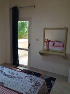 a bedroom with a mirror and a bed and a window at الغردقه البحر الاحمر مبارك 6 in Hurghada