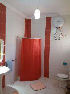 a bathroom with a red shower curtain and a toilet at الغردقه البحر الاحمر مبارك 6 in Hurghada