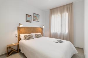 um quarto com uma grande cama branca e uma janela em Calella Apartments by Olala Homes em Calella