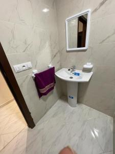 ein Bad mit einem Waschbecken und einem Spiegel in der Unterkunft Residence Al-Bahr in Mʼdik
