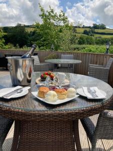 a table with a plate of food and a bottle of wine at Dartmoor Lodge Hotel in Ashburton