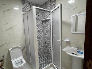 ein Bad mit einer Dusche, einem WC und einem Waschbecken in der Unterkunft Residence Al-Bahr in Mʼdik