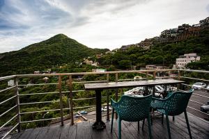 un tavolo e sedie su un balcone con vista sulle montagne di Shabby Home 28 a Jiufen