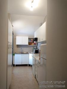 een kleine keuken met witte kasten en een koelkast bij Appartamenti Vista Gransasso in LʼAquila