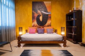 a bedroom with a bed with a painting on the wall at No1 Art B&B in Au