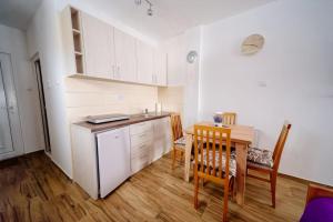 a kitchen with a table and a dining room at Apartmani Šarović Tara in Rača