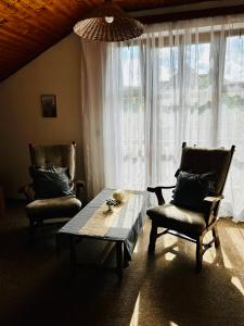 un soggiorno con tavolo, due sedie e finestra di Hvězdonice Hostinec U Kuželků a Hvězdonice