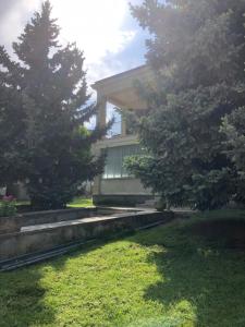 a building with trees in front of a yard at Casa del Dottore in Fano Adriano