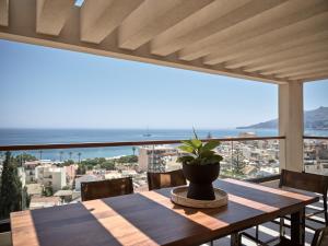 a wooden table with a potted plant on a balcony at Salita - Comfort Living Apartments in Zakynthos Town
