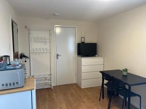 a small kitchen with a table and a microwave at Kensal Lodge 2 Guest House in London +55 photos