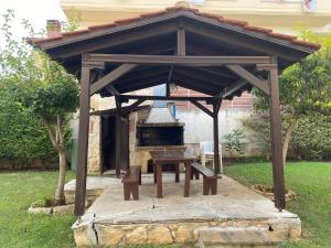 a wooden pavilion with a picnic table and a grill at ART-appart sea view in Kallithea Halkidikis