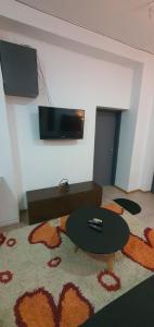um quarto com uma mesa e uma televisão na parede em Calipso1 em Niš