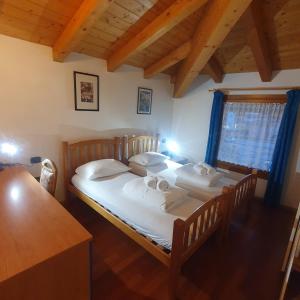 2 Einzelbetten in einem Zimmer mit Holzboden in der Unterkunft GARDAINN La CASCINA in Riva del Garda