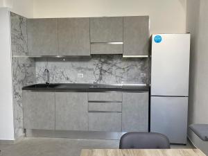クアルトゥ・サンテーレナにあるLoft Anna d’Este - design & garden -のキッチン(白い冷蔵庫、グレーのキャビネット付)