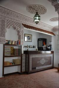 a living room with a fireplace and a chandelier at Hotel Marrakech in Chefchaouene