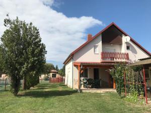 a white house with a yard with a tree at Lukács nyaralóház in Balatonfenyves