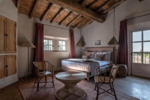 1 dormitorio con 1 cama, mesa y sillas en Les Petites Maisons - Hameau des Baux, en Paradou