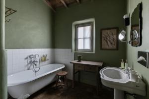 a green bathroom with a tub and a sink at Les Petites Maisons - Hameau des Baux in Paradou