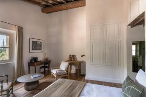 a bedroom with a bed and a table and a chair at Les Petites Maisons - Hameau des Baux in Paradou