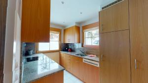 a kitchen with wooden cabinets and granite counter tops at Greina in Celerina