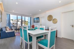 a dining room and living room with a white table and chairs at Casa Ayla in Carvoeiro