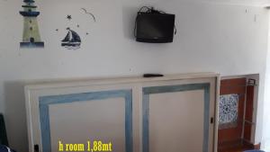 a tv on the wall above two glass doors at Casa Barbara in Amalfi