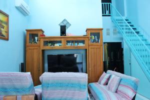a living room with a fireplace and a tv at KJ Blue House Senggigi in Senggigi
