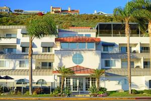 a building with palm trees in front of it at Riviera Beach & Shores Resorts in Capistrano Beach