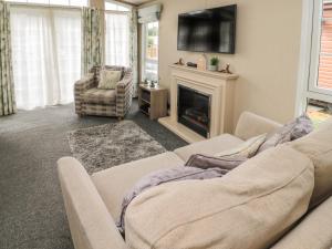 a living room with a couch and a fireplace at Lemon Tree lodge in Morpeth
