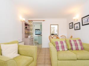 a living room with two chairs and a couch at Forge Cottage in Helston