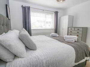 um quarto com uma cama grande com almofadas e uma janela em Cynefin em Llangefni