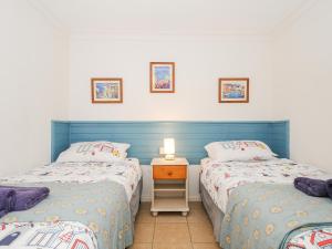 a bedroom with two beds and a table with a lamp at Forge Cottage in Helston +22 photos