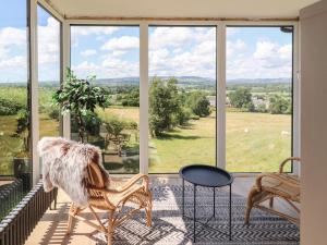 a room with a large window with a chair and a table at Dunster Cottage in Clitheroe