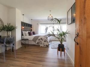 a bedroom with a bed and a potted plant at Dunster Cottage in Clitheroe