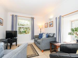 a living room with a couch and a tv at Dairy Cottage in Helston
