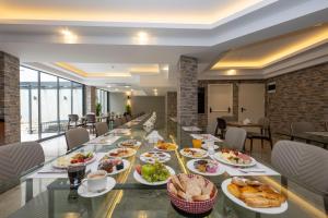 Hotel Ravi في إسطنبول: طاولة طويلة عليها أطباق من الطعام