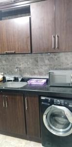 eine Küche mit einer Waschmaschine und einem Waschbecken in der Unterkunft عماره الاطباء in Alexandria